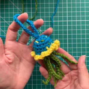 An image of a crochet jellyfish being held