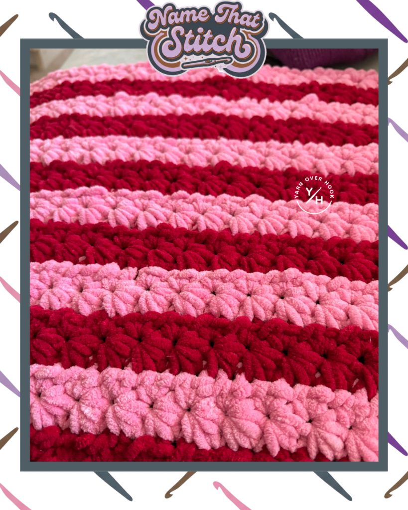 Close-up of a crocheted swatch with raised stitch rows in alternating red and pink yarn, featured as part of the Name That Stitch daily crochet puzzle and stitched by @lindamarieluisa on Instagram