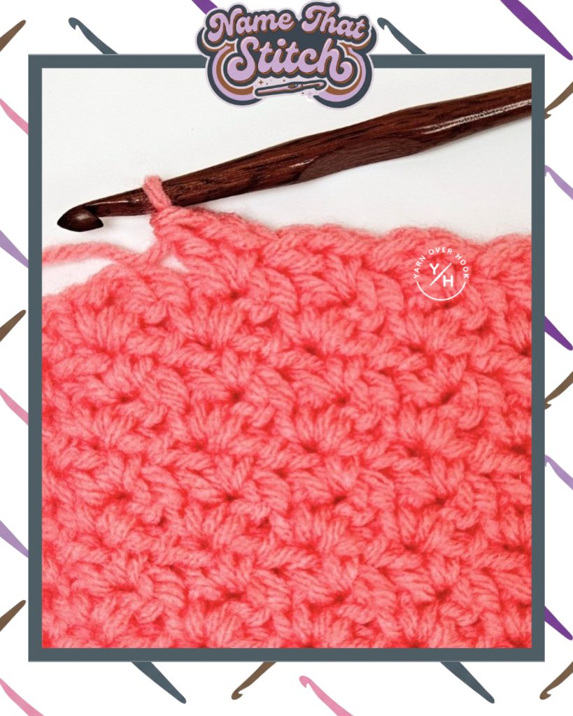 Close-up of a crocheted fabric displaying a repeating stitch pattern worked in pink yarn, with a wooden crochet hook and featured as part of the Name That Stitch daily crochet puzzle. View more at NameThatStitch.com