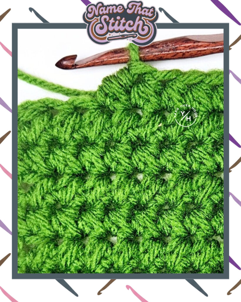 Close-up of a crocheted fabric displaying a repeating stitch pattern worked in green yarn, with a wooden crochet hook and featured as part of the Name That Stitch daily crochet puzzle. View more at NameThatStitch.com
