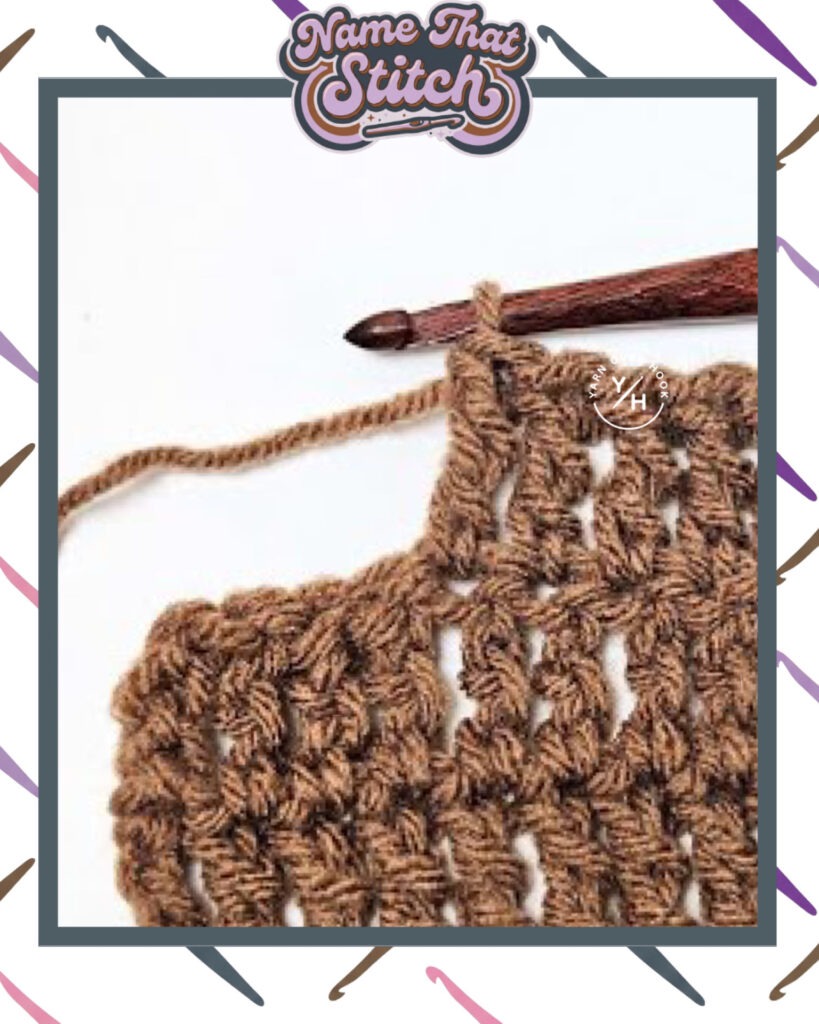 Close-up of a crocheted fabric displaying a repeating stitch pattern worked in brown yarn, with a wooden crochet hook and featured as part of the Name That Stitch daily crochet puzzle. View more at NameThatStitch.com