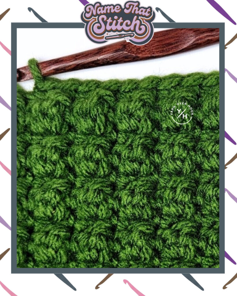 Close-up of a crocheted fabric displaying a repeating stitch pattern worked in green yarn, with a wooden crochet hook and featured as part of the Name That Stitch daily crochet puzzle. View more at NameThatStitch.com