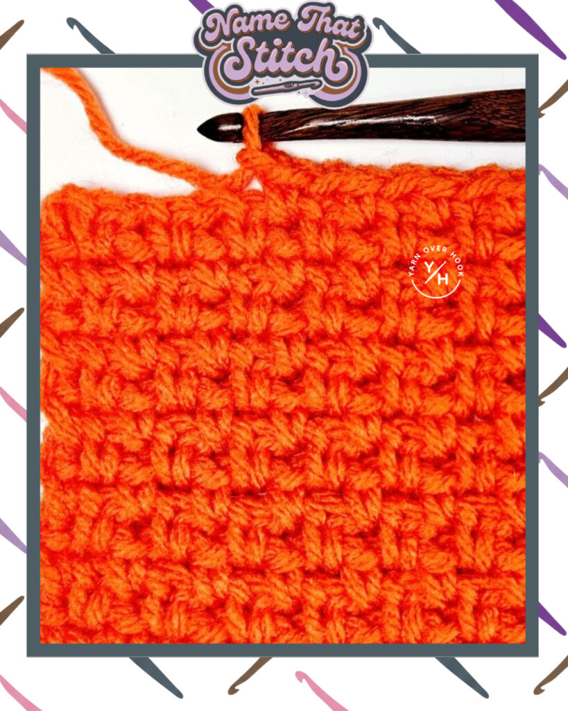 Close-up of a crocheted fabric displaying a repeating stitch pattern worked in orange yarn, with a wooden crochet hook and featured as part of the Name That Stitch daily crochet puzzle. View more at NameThatStitch.com