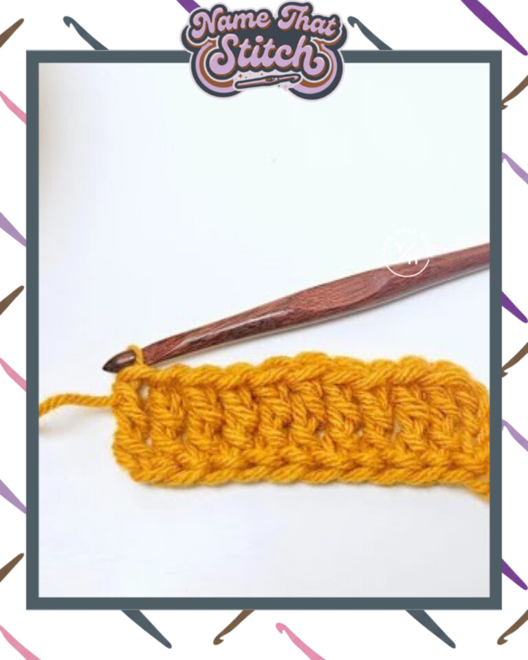 Close-up of a crocheted fabric displaying a repeating stitch pattern worked in yellow colored yarn, with a wooden crochet hook and featured as part of the Name That Stitch daily crochet puzzle. View more at NameThatStitch.com