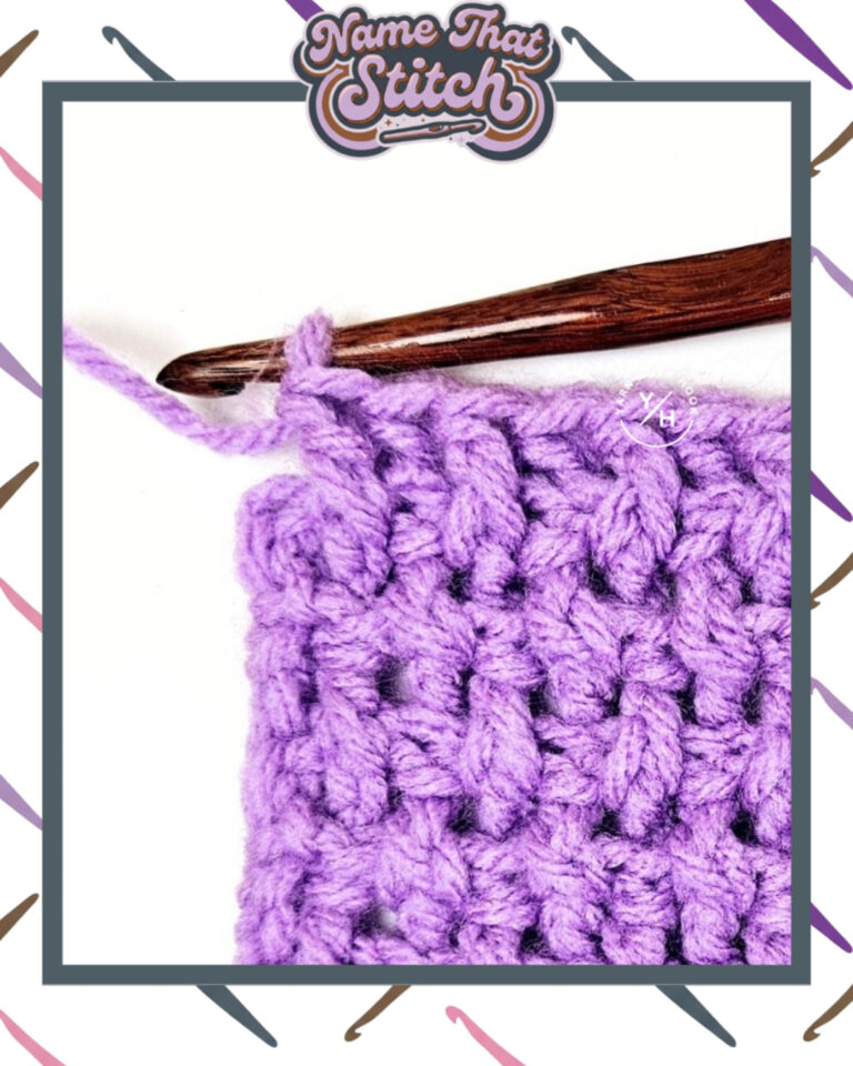 Close-up of a crocheted fabric displaying a repeating stitch pattern worked in purple colored yarn, with a wooden crochet hook and featured as part of the Name That Stitch daily crochet puzzle. View more at NameThatStitch.com