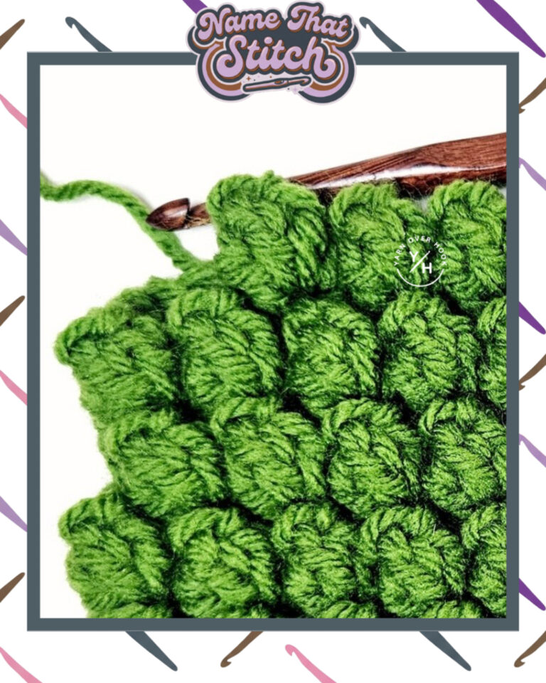 Close-up of a crocheted fabric displaying a repeating stitch pattern worked in green colored yarn, with a wooden crochet hook and featured as part of the Name That Stitch daily crochet puzzle. View more at NameThatStitch.com