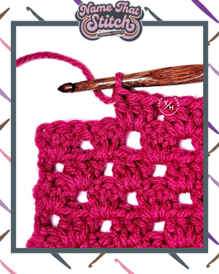 Close-up of a crocheted fabric displaying a repeating stitch pattern worked in raspberry colored yarn, with a wooden crochet hook and featured as part of the Name That Stitch daily crochet puzzle. View more at NameThatStitch.com
